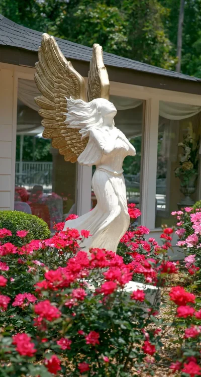statue of lady angel with wings and blooms